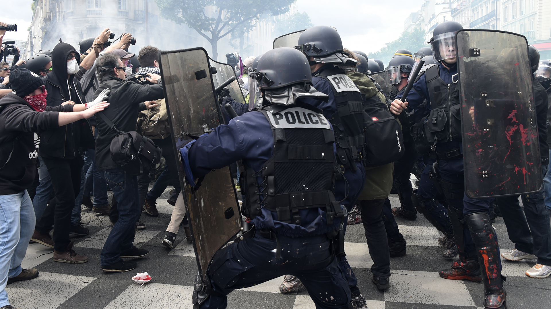 French anti-riot police clash with protesters during a demonstration against proposed labour reforms in Paris on June 14, 2016.  Several hundred masked protesters hurled objects at police on June 14 during a demonstration in Paris against a contested reform of French labour laws, authorities said. / AFP PHOTO / DOMINIQUE FAGET