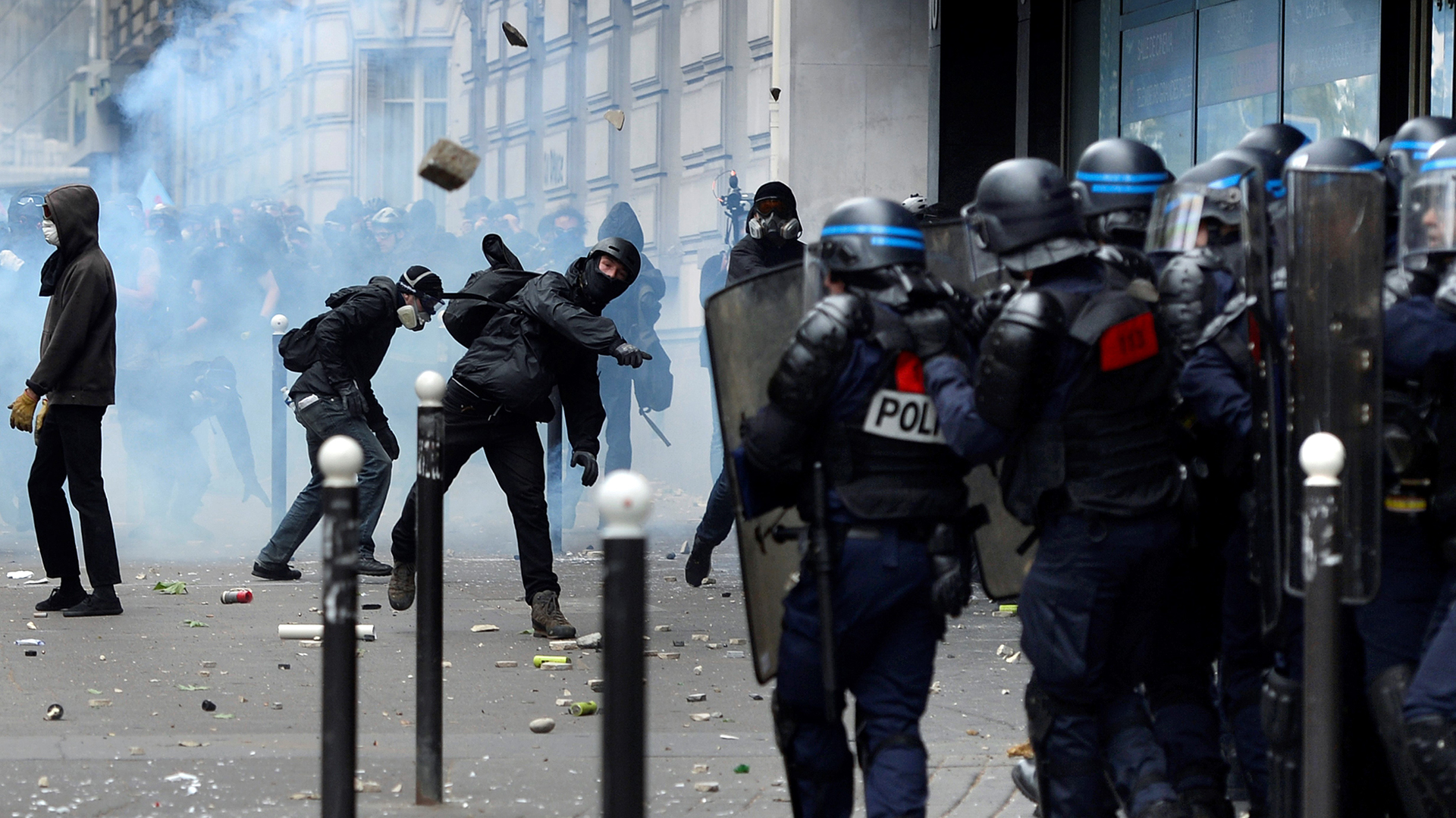 Demonstrators clash with police officers during a protest against proposed labour reforms in Paris on June 14, 2016.  Strikes closed the Eiffel Tower and disrupted transport in France on June 14 as tens of thousands prepared to march against labour reforms with the Euro 2016 football championship in full swing.  / AFP PHOTO / ALAIN JOCARD