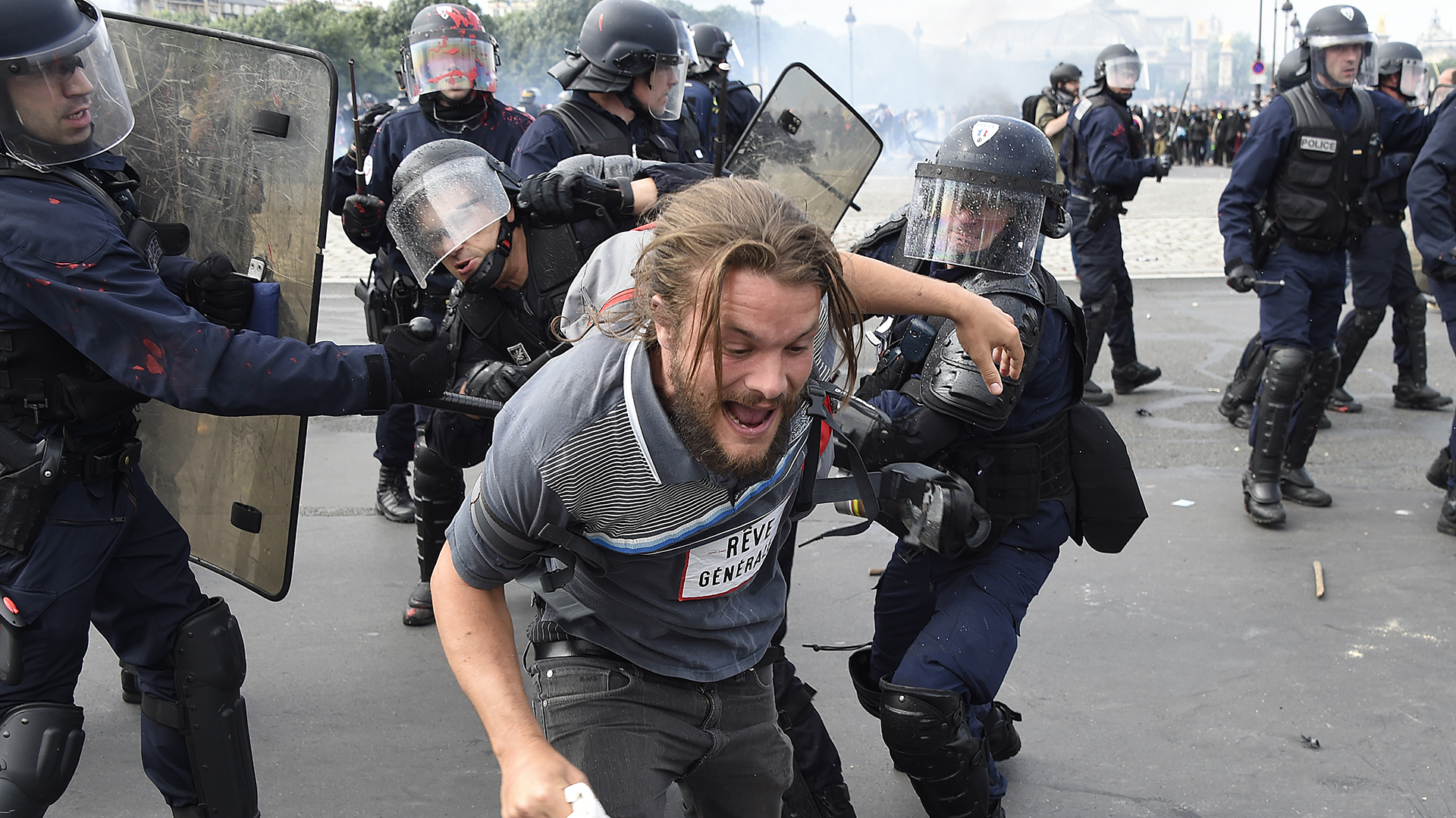 Demonstrators clash with riot police near the Invalides during a protest against proposed labour reforms in Paris on June 14, 2016.  Strikes closed the Eiffel Tower and disrupted transport in France on June 14 as tens of thousands prepared to march against labour reforms with the Euro 2016 football championship in full swing.  / AFP PHOTO / DOMINIQUE FAGET