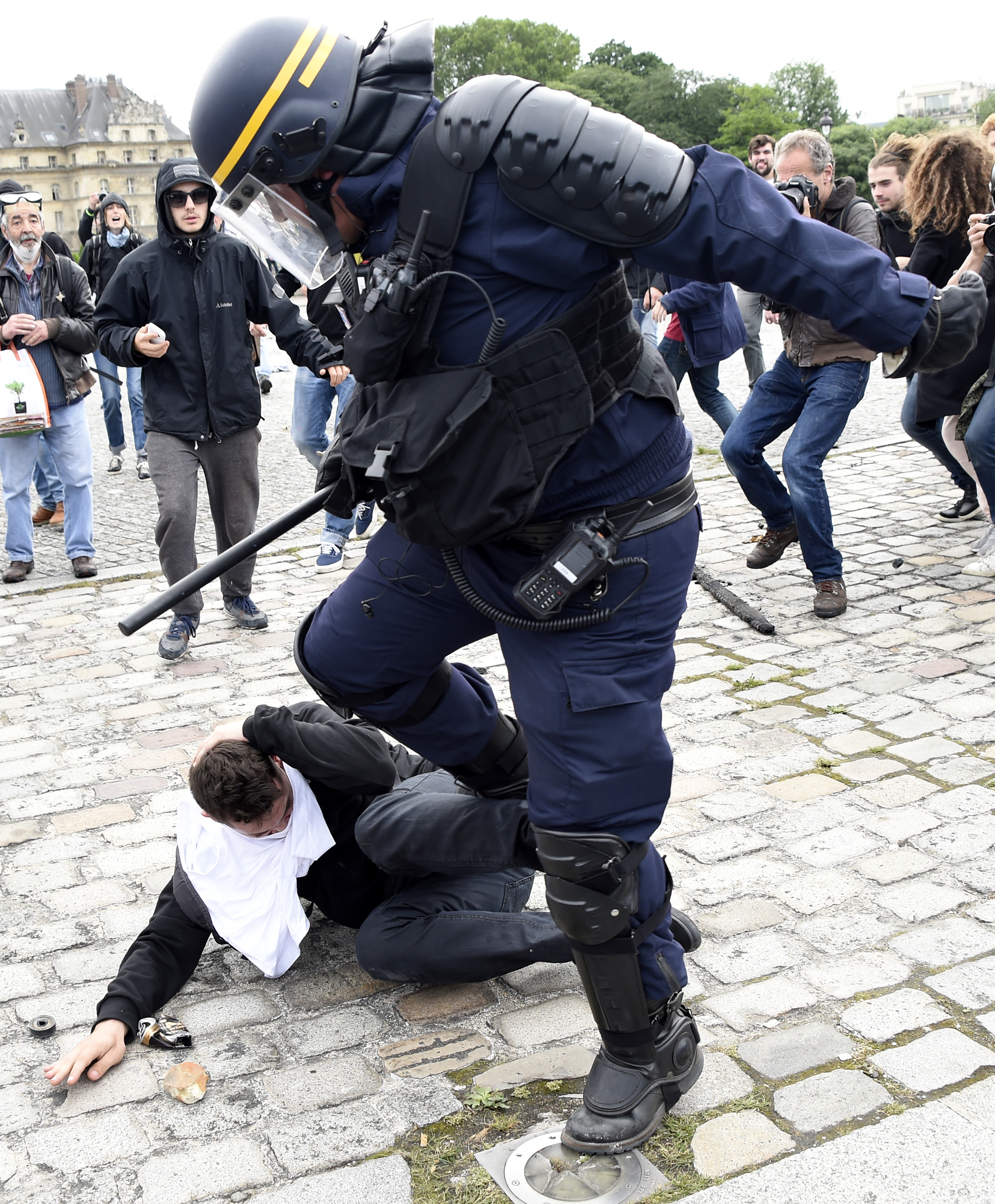 A police officer clashes with a demonstrator near the Invalides during a protest against proposed labour reforms in Paris on June 14, 2016.  Strikes closed the Eiffel Tower and disrupted transport in France on June 14 as tens of thousands prepared to march against labour reforms with the Euro 2016 football championship in full swing.  / AFP PHOTO / DOMINIQUE FAGET