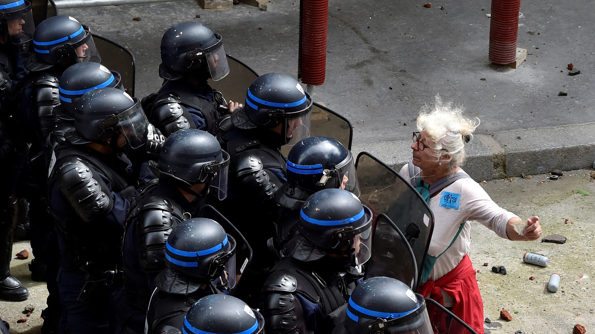 A woman stands in front of police officers as they block access to a street during a protest against proposed labour reforms in Paris on June 14, 2016.  Strikes closed the Eiffel Tower and disrupted transport in France on June 14 as tens of thousands prepared to march against labour reforms with the Euro 2016 football championship in full swing.  / AFP PHOTO / ALAIN JOCARD