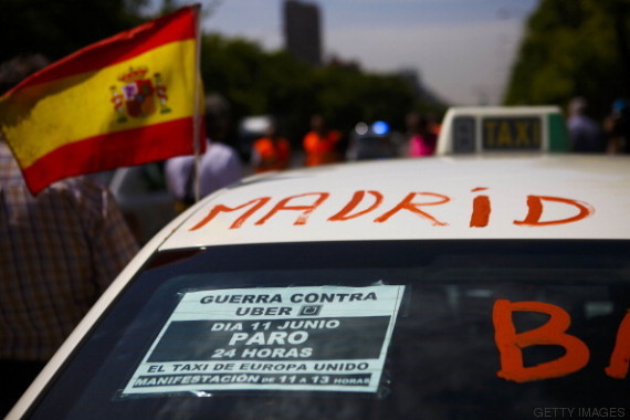 A Spanish flag flies from a taxi cab during a demonstration by cabbies to protest against the Uber Technologies Inc. taxi app in central Madrid, Spain, on Wednesday, June 11, 2014. Uber, the car-sharing service that's rankling cabbies across the U.S., is fighting its biggest protest yet from European drivers who say the smartphone application threatens their livelihoods. Photographer: Angel Navarrete/Bloomberg via Getty Images
