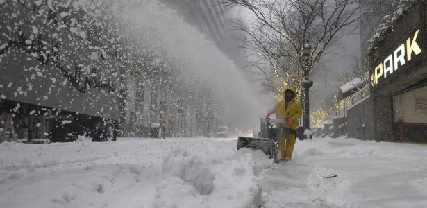 zzzzinte1A worker clears snow from a sidewalk on January 23, 2016 in New York. A deadly blizzard with bone-chilling winds and potentially record-breaking snowfall slammed the eastern US on January 23, 2016, as officials urged millions in the storm's path to seek shelter -- warning the worst is yet to come.  / AFP / Don EMMERTzzzz